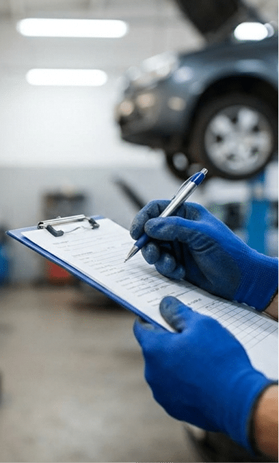 Mechanic completing a vehicle service checklist in the workshop
